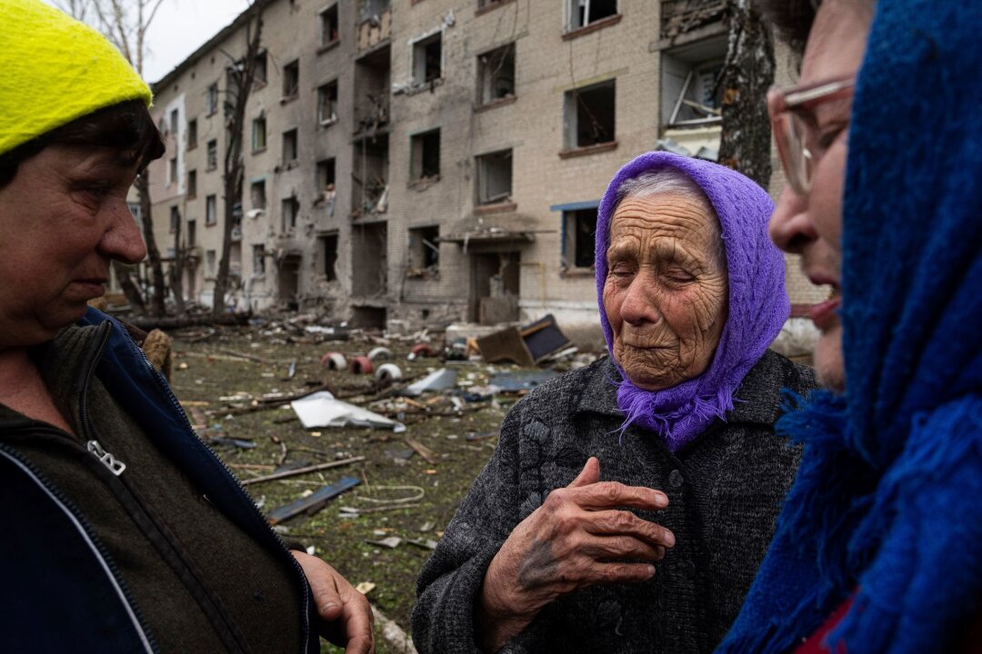 Krieg gegen die Ukraine: So ist die Lage - Frauen stehen in Lukiantsi in der Region Charkiw vor einem Haus, das durch einen russischen Luftangriff schwer beschädigt wurde.