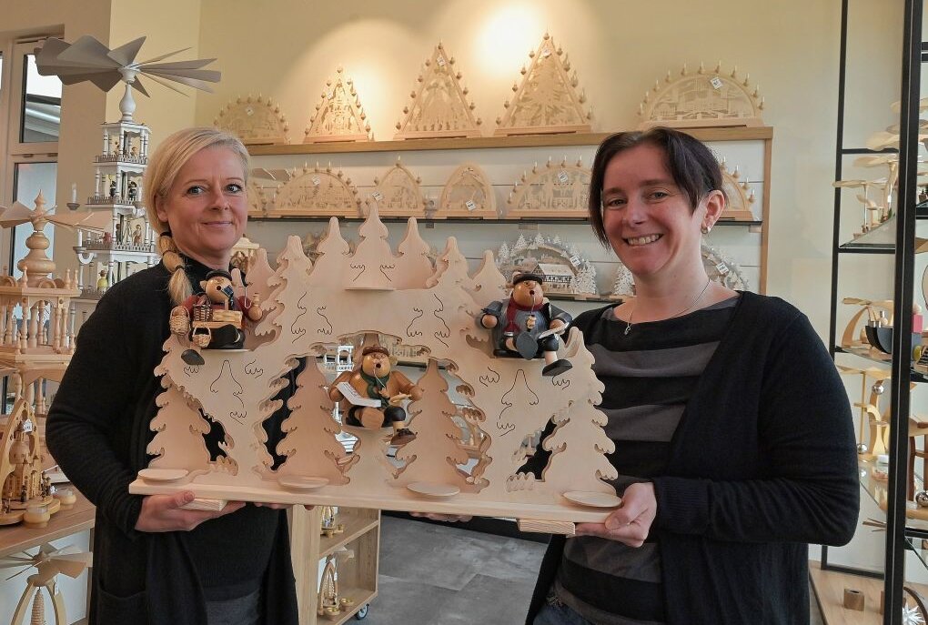 Kunsthandwerk-Geschäft ist neu gestaltet - Die Mitarbeiterinnen Cathrin Freier (li.) und Sandra Herold (re.) halten einen der Sammler-Schwibbögen aus eigener Produktion in den Händen.Foto: Ralf Wendland