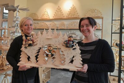 Kunsthandwerk-Geschäft ist neu gestaltet - Die Mitarbeiterinnen Cathrin Freier (li.) und Sandra Herold (re.) halten einen der Sammler-Schwibbögen aus eigener Produktion in den Händen.Foto: Ralf Wendland