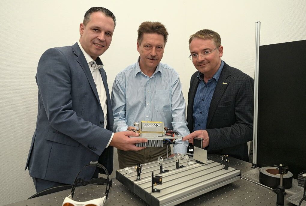 Der Landtagsabgeordnete Rico Anton (li.) lässt sich von Fred Kallweit von LEC (Mitte) und LEC-Geschäftsführer Enrico Oswald einen Justage-Laser für die Halbleiter-Industrie erklären. Foto: Ralf Wendland