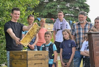 Lebenshilfe Stollberg hat buntes Sommerfest gefeiert - Yves Krone, Mitarbeiter der Agrargenossenschaft Lößnitz-Stollberg (li.) hat gezeigt, wie ein Bienenstock von innen aussieht und hat Fragen rund um die Biene beantwortet. Foto: Ralf Wendland