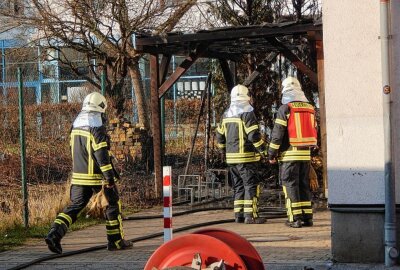 Leipzig: Mülltonne unter Holzstand brennt - Polizei ermittelt - Aus bisher unbekannter Ursache war hier ein Holzunterstand in Brand geraten. Foto: Anke Brod