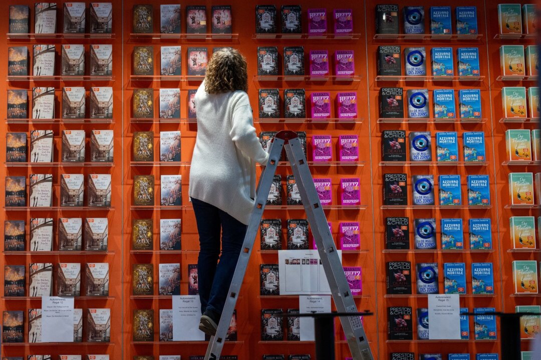 Leipziger Buchmesse will für Demokratie kämpfen - Eine Mitarbeiterin bestückt den Stand von Droemer Knaur auf der Leipziger Buchmesse. Auf dem Frühjahrstreffen der Buchbranche präsentierten sich ab Donnerstag (21.03.) bis Sonntag über 2000 Aussteller aus 40 Ländern mit ihren Neuheiten.