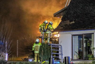 Leutersdorf: Holzstapelbrand greift auf Haus über und verletzt Feuerwehrmann - Der Brand griff rasch auf das Wohnhaus über und setzte den Dachstuhl in Brand. Foto: Xcitepress