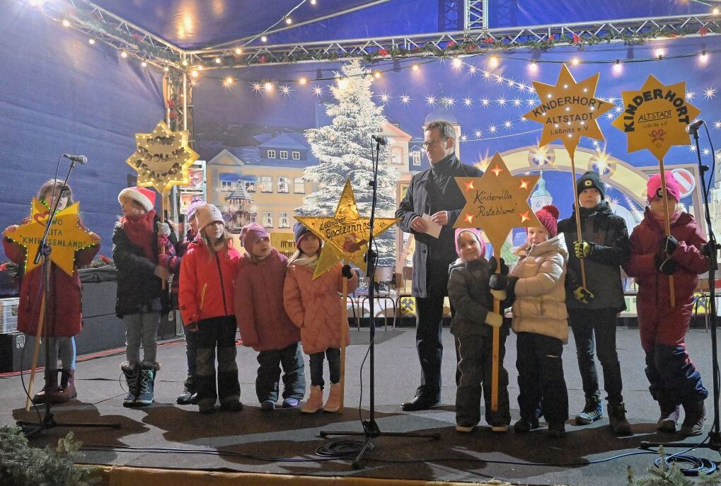 Lößnitzer Weihnachtsmarkt ist eröffnet! - Die Mädchen und Jungen der Lößnitzer Kindertagesstätten haben das Licht in die Stadt getragen - hier Vertreter der Einrichtungen mit Bürgermeister Alexander Troll. Foto: Ralf Wendland