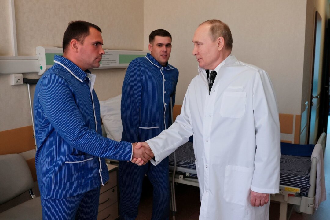 London: Kliniken in Russland leiden unter Aufwand für Krieg - Russlands Präsident Wladimir Putin (r.) während eines Besuchs von verletzten Gefreiten im zentralen Militärkrankenhaus in Moskau.