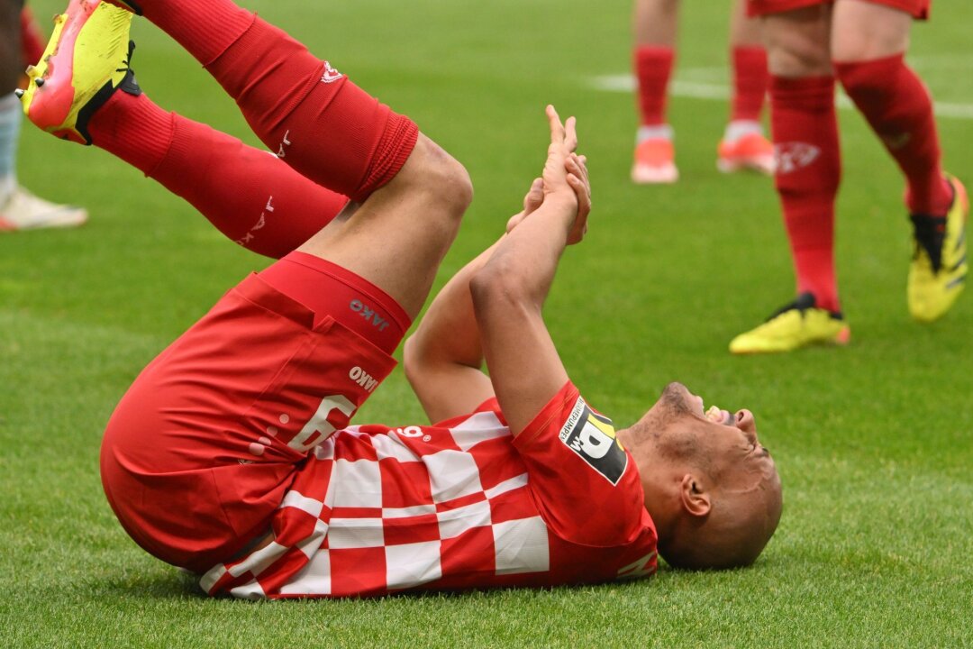 Mainzer Angreifer Onisiwo bricht sich drei Finger - Der Mainzer Karim Onisiwo liegt mit einer verletzten Hand am Boden.