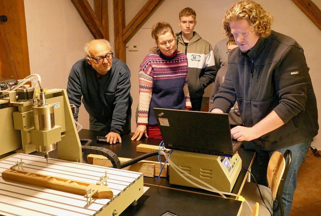 Maker-Advent in Augustsburg bietet Hutzenabende moderner Art - An seinem Laptop erklärt Lars Faßmann, wie man die moderne Fräsmaschine programmiert. Foto: Andreas Bauer