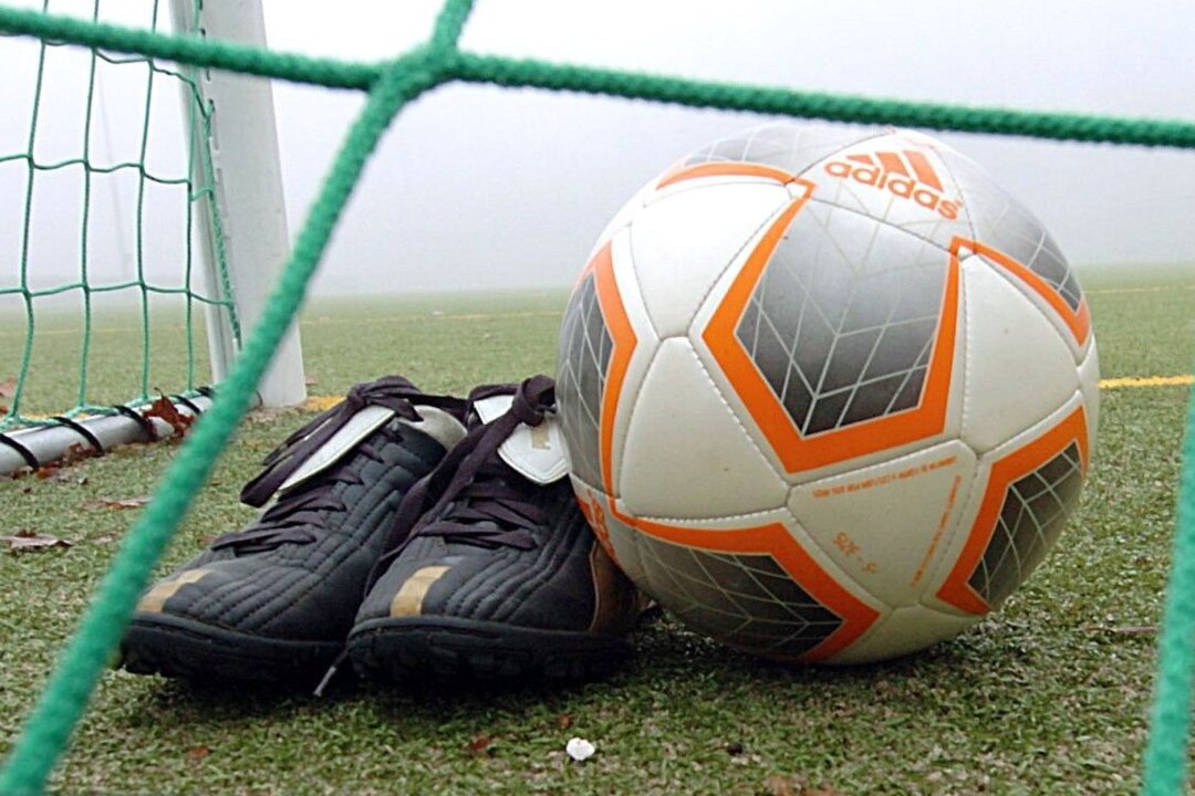 Mehr als 220.000 Euro für sechs sächsische Sportvereine - Fußballschuhe und ein Ball liegen hinter einem Tornetz.