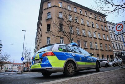 Mehrere Verletzte nach Brand in Leipziger Mehrfamilienhaus - Ein Streifenwagen steht vor dem Gebäude in dem sich der Brnad ereignete. Foto: Christian Grube