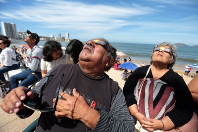 Millionen Menschen sehen totale Sonnenfinsternis - Menschen haben sich im Hafen von Mazatlán in Mexiko versammelt, um die totale Sonnenfinsternis beobachten.