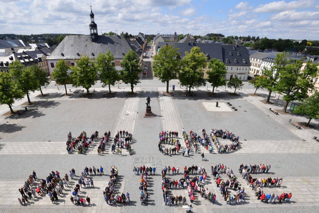Millionenförderung für sächsisch-tschechische Kooperationen - Schüler des Gymnasiums Marienberg und Bürger der Stadt bilden den Schriftzug "Wir sind Welterbe".