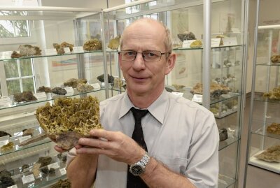Axel Hiller, Leiter Geologisches Archiv der Wismut GmbH, zeigt eine der Mineralstufen, die in der Ausstellung zu sehen sind. Foto: Ralf Wendland
