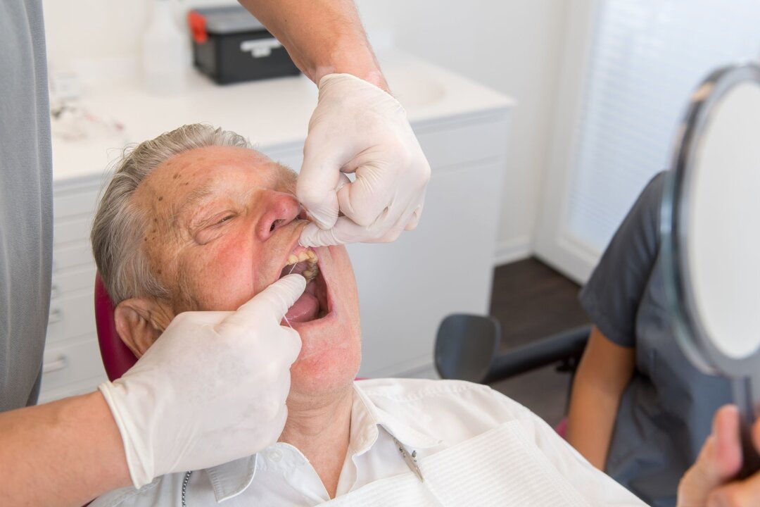 Mit guter Mundhygiene Wurzelkaries vorbeugen - Regelmäßige professionelle Zahnreinigungen und tägliche Zahnseidenpflege sind entscheidend zur Vermeidung von Wurzelkaries, besonders im Alter (zu dpa: "Mit guter Mundhygiene Wurzelkaries vorbeugen")