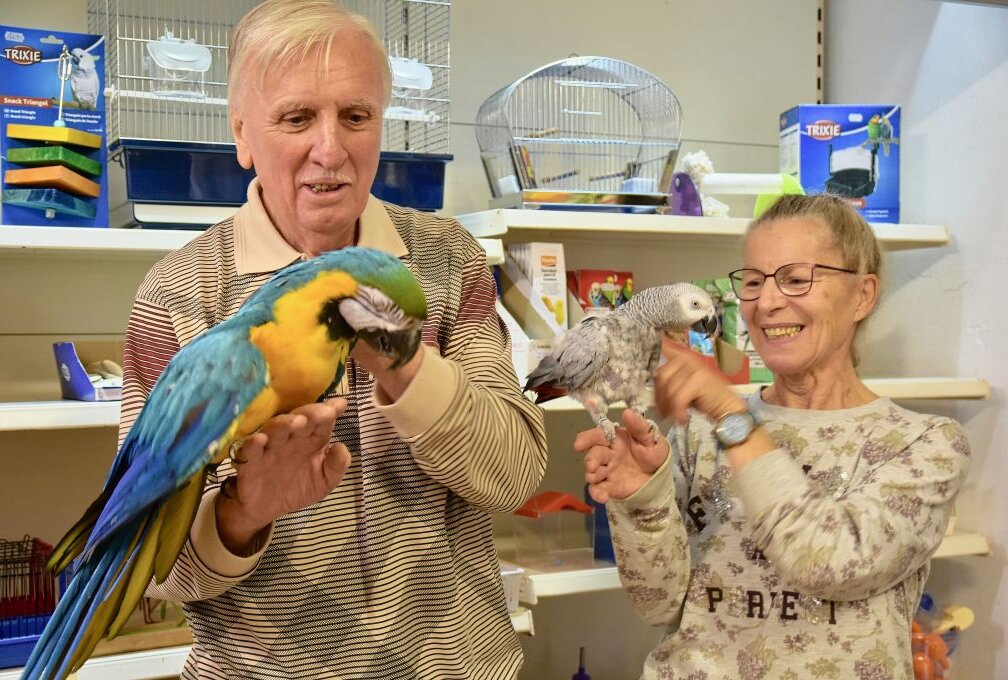 Klaus und Martina Lawnik mit ihren zwei Papageien Lolita und Rudi. In wenigen Wochen schließt die Zoohandlung ihre Türen. Foto: Steffi Hofmann