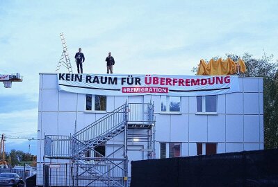 Neonazis besetzen geplante Asylunterkunft - "Kein Raum für Überfremdung": Demonstranten rufen Sprechchöre vom Dach. Foto: xcitepress/Benedict Bartsch