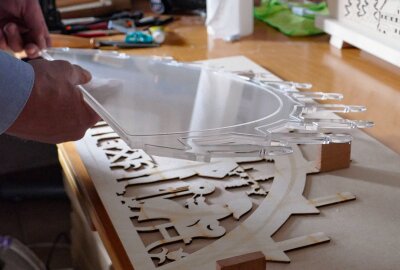 Neue Schwibbogen-Version aus Drebach - Zwischen zwei Holzplatten, auf denen das Motiv ausgesägt ist, klebt er eine Kunstoffscheibe. Foto: Andreas Bauer