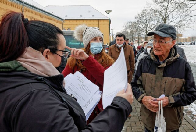 Die Helfer vom Vogtlandkreis verteilen vor der Halle Zettel mit aufgedruckten Nummern sowie Einwilligungsformulare . Foto: Thomas Voigt 