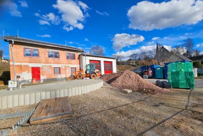 Das neue Feuerwehrgerätehaus in Auerswalde mit Containern und im Hintergrund blauem Himmel.