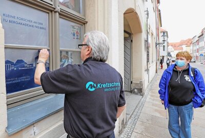 Neues Regionalbüro für Weiterbildung von Erziehern in Freiberg - Perfekt bringt Andreas Kretzschmar die Folien auf die Fenster. Koordinatorin Kathrin Häußler freut das. Foto: Wieland Josch