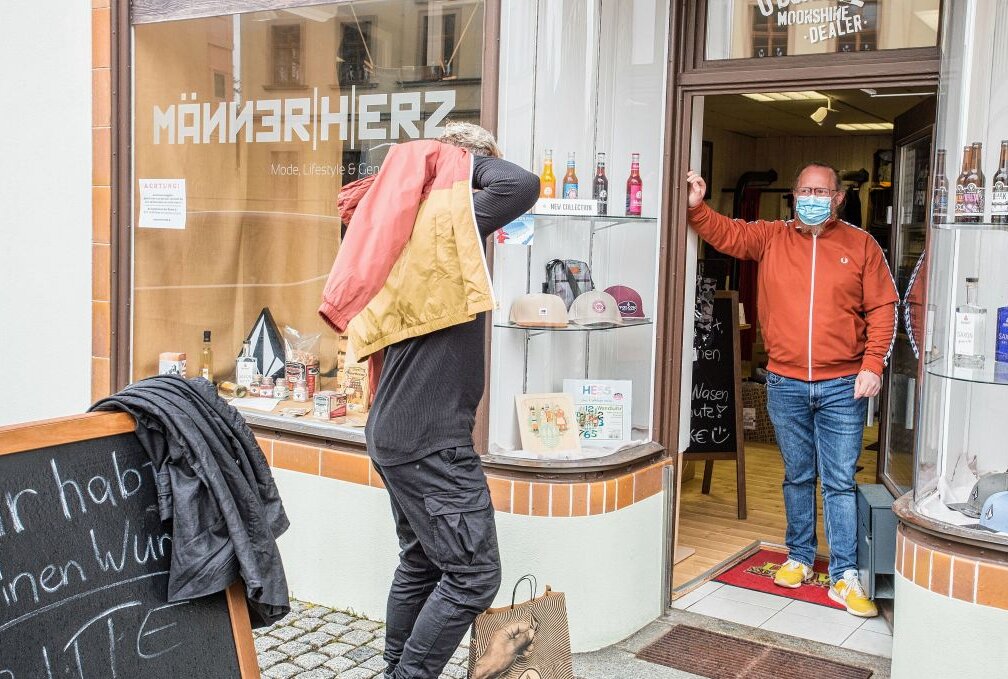 Olbernhau: Weil's drin nicht geht, wird auf der Straße anprobiert - Hans B. (li.) probiert vor dem "Männerherz" eine Jacke an - rechts Marco Hunger. Foto: Jan Görner