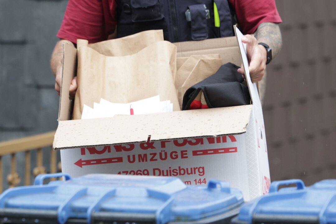 Palästina-Verein verboten - Razzia in Duisburg - Ein Polizist trägt nach einer Wohnungsdurchsuchung einen Karton mit sichergestellten Gegenständen.