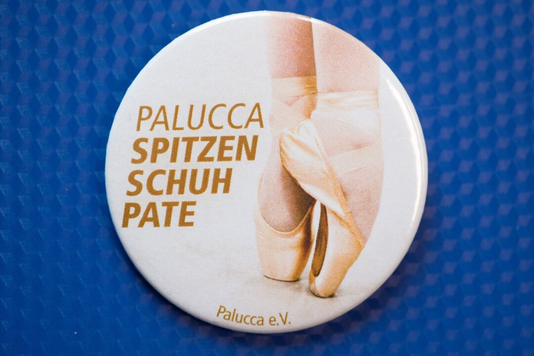Palucca-Stiftungsfonds will neue Unterstützer finden - Ein Ansteckbutton der Palucca Hochschule für Tanz mit der Aufschrift "Palucca Spitzenschuhpate" liegt auf einem Tisch.
