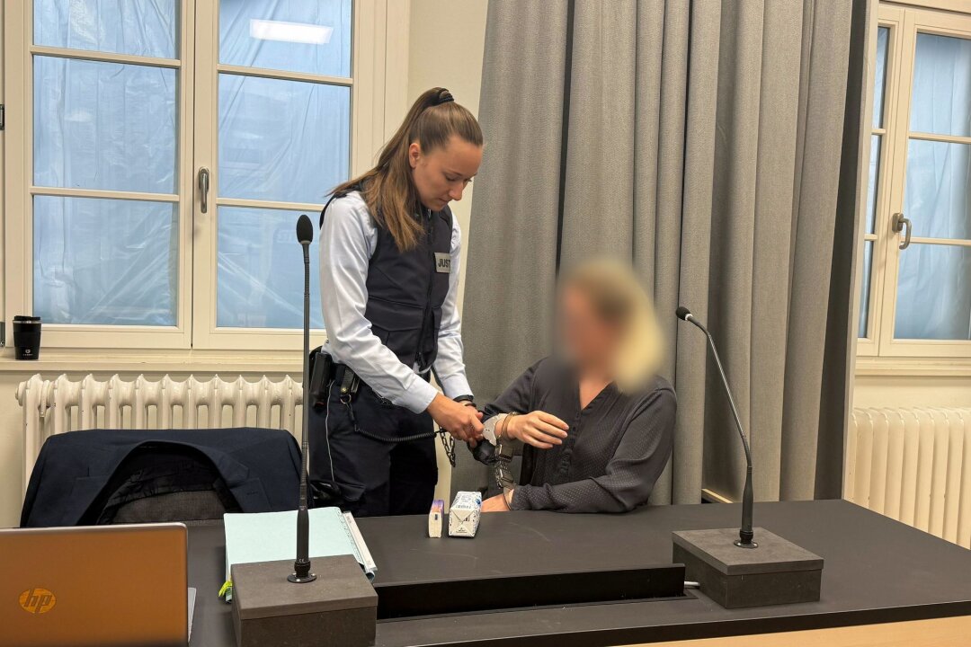 Partner aus Frust getötet? 36-Jährige schweigt vor Gericht - Eine Justizmitarbeiterin nimmt der Angeklagten beim Prozessauftakt vor dem Landgericht Ravensburg die Handschellen ab.