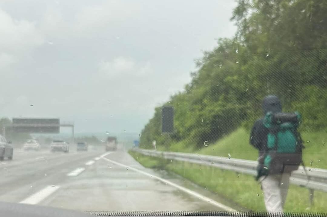 Person in Regenkleidung läuft auf A4 Chemnitz Ost in Richtung Dresden. 