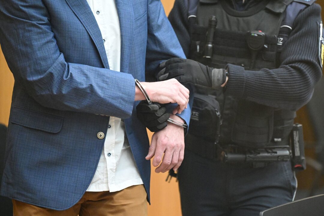 Prozess gegen "Reichsbürger"-Gruppe von Prinz Reuß rollt an - Ein Angeklagter bei Prozessbeginn in den Gerichtssaal geführt.