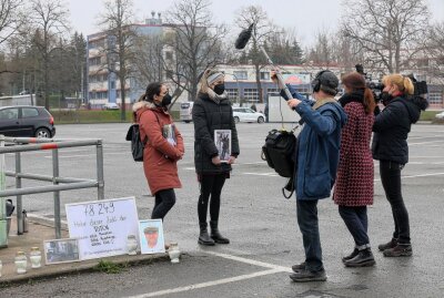 Querdenker-Demo auf Platz der Völkerfreundschaft in Zwickau - Zwei Frauen protestierten still mit Kerzen, Plakaten und Bildern der verstorbenen Väter. Foto: Ralph Koehler/propicture