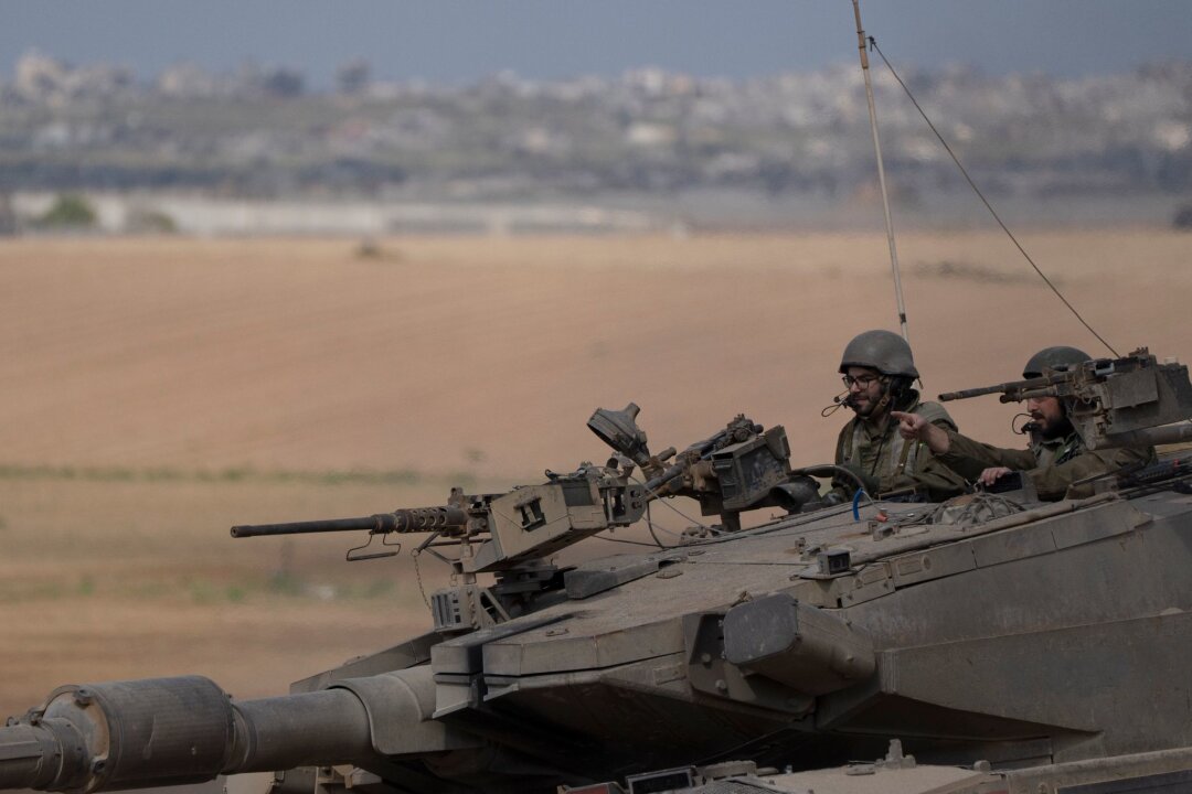 Ramadan endet ohne Waffenruhe in Gaza - Israelische Soldaten fahren auf einem Panzer nahe der Grenze zwischen Israel und Gaza.