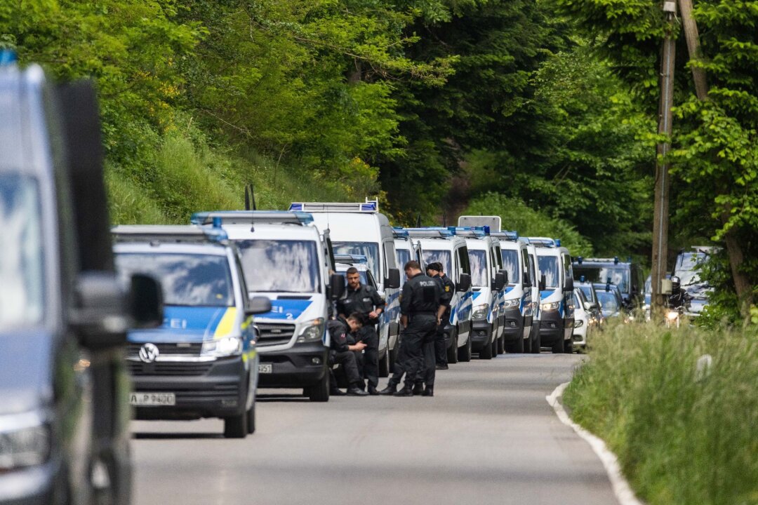 "Reichsbürger"-Terrorgruppe: Razzia - Polizeibeamte stehen auf einer Straße nahe Bad Teinach.