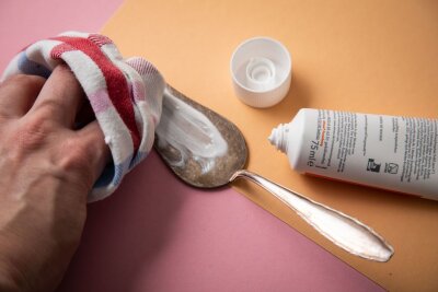 Reinigungshack: Silberbesteck mit Zahnpasta reinigen - Schritt 2: Die Zahnpasta wird mit einem Tuch verrieben.