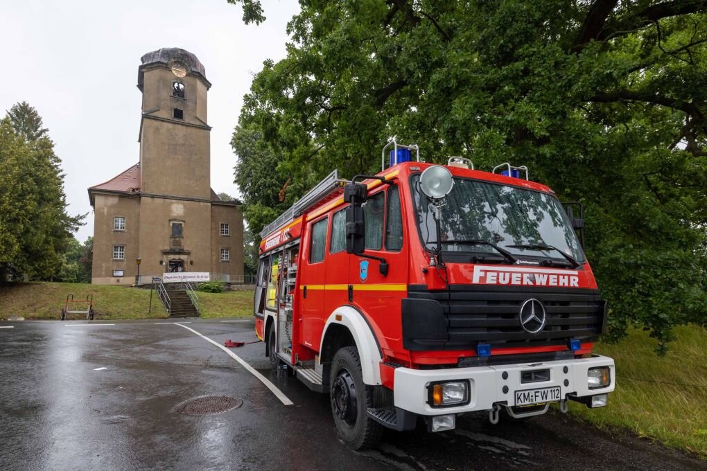 "Riesiger Verlust": Feuer zerstört Kirche in Großröhrsdorf - Ein Fahrzeuge der Feuerwehr ist vor der Stadtkirche Großröhrsdorf zu sehen.