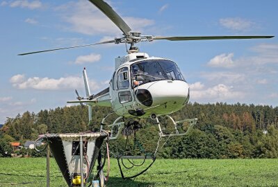 Sachsenforst startet im Forstbezirk Plauen Bodenschutz-Kalkung - Der Helikopter vom Typ AS 350 startet mit dem Kalkbehälter in Richtung Beladeplatz. Foto: Thomas Voigt