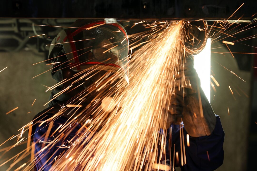 Sachsens Maschinenbau setzt Wachstumstrend fort - Ein Mitarbeiter eines Maschinenbauers schneidet mit einem Trennschleifer korrodierte Metallteile aus dem Träger in einem Wagenkasten.