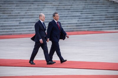 Scholz und Xi wollen Frieden in der Ukraine - Bundeskanzler Olaf Scholz wird von Ministrpräsident Li Qiang (r) mit militärischen Ehren vor der Großen Halle des Volkes empfangen.