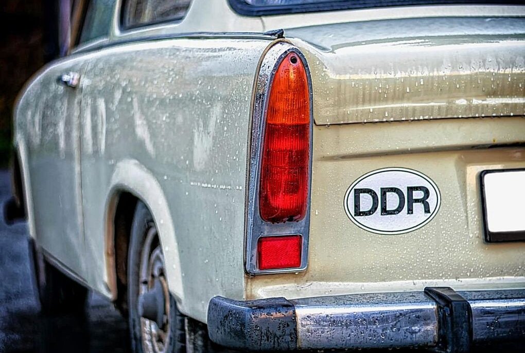 Senior mit DDR-Kennzeichen weist sich als DDR-Bürger aus - Symbolbild. Ein PKW mit einem Aufkleber "DDR" auf dem Heck. Foto: Pixabay