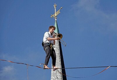 Sportler balancieren in 20 Metern Höhe über den Opernplatz - Der 26-jährige Ruben Langer, Weltrekordhalter, jonglierte und spielte Posaune in 20 Metern Höhe. Foto: Harry Härtel/Haertelpress