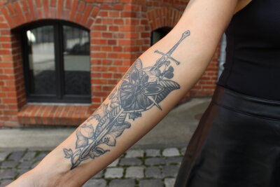 Stefanie (27) aus Chemnitz: Die beeindruckende Welt der Tattoos und deren Bedeutung - "Ich habe mich dann für meinen Unterarm für eine Tätowiererin aus der Ukraine entschieden." Sie hat ein Motiv von Herr der Ringe gezaubert. Es zeigt das Schwert von Aragon und die neun Gefährten."
