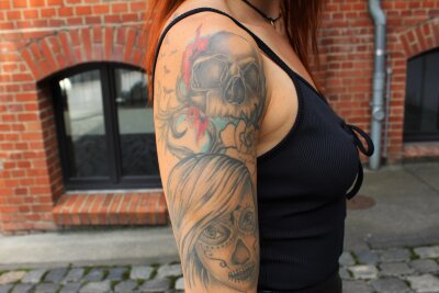 Stefanie (27) aus Chemnitz: Die beeindruckende Welt der Tattoos und deren Bedeutung - Das mexikanische Frauengesicht zum "Dia de los Muertos" erinnert an ihre verstorbene Uroma. 