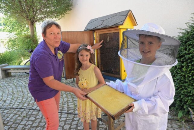 Ute Adelt vom Imkerverein Stollberg (li.) hat den Geschwistern Noralie und Eliano Vater einiges zum Thema Bienen erklärt. Foto: Ralf Wendland