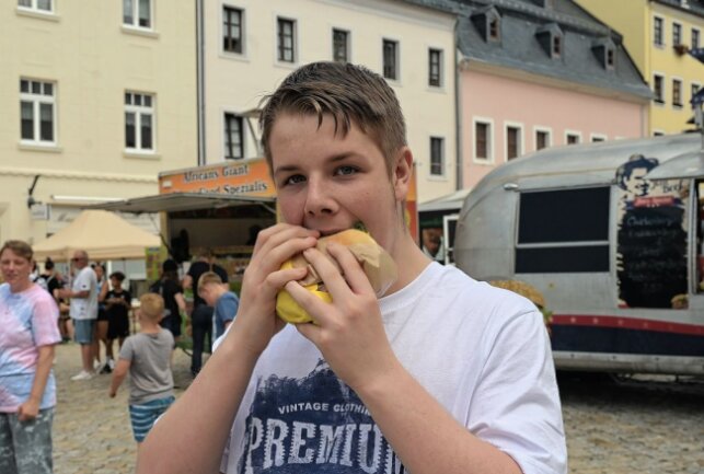Besucher lassen es sich schmecken beim Streetfood-Festival in Schneeberg - im Bild Toni Ungethüm. Foto: Ralf Wendland