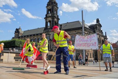 Streik in Dresden: Gebäudereiniger fegen die Albertbrücke -  Etwa 25 Gebäudereiniger bei einer Streikkundgebung in Dresden. Foto: xcitepress