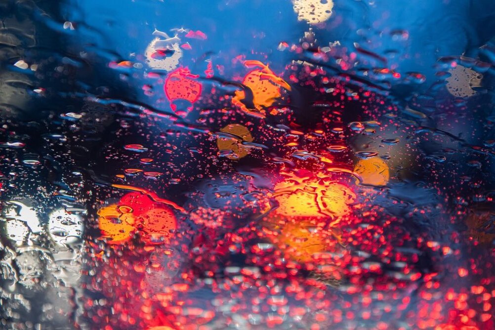 Regentropfen sind auf einer Autoscheibe zu sehen.