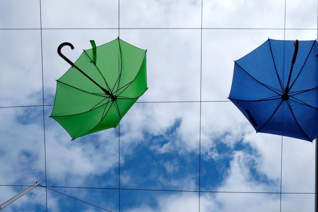 Stürmisches Wetter nach Feiertagen in Sachsen - Regenschirme hängen zu Dekorationszwecken über dem Freisitz eines Eiscafés am Augustusplatz.