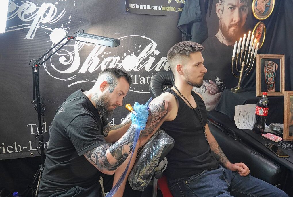 Tattoo-Convention in Zwickau gut besucht - Profi Kevin Frank aus Chemnitz tätowiert Max Freund ein fotorealistisches Tattoo. Foto: Mario Dudacy