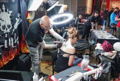 Tattoo-Convention in Zwickau gut besucht - Kristijan Svelec zaubert einen Schmetterling auf den Rücken einer jungen Frau. Foto: Mario Dudacy