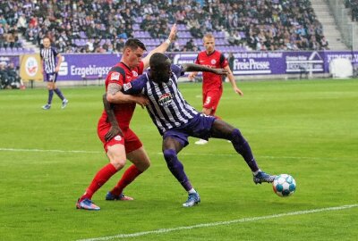 Traditionsduell zwischen FC Erzgebirge Aue und Hansa Rostock endet mit Remis - Prince Osei Owusu (rechts) schirmt den Ball ab.  Foto: Alexander Gerber